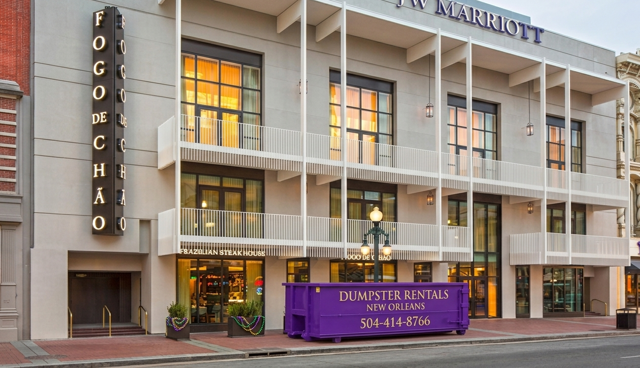 Purple NOLA Dumpster Rentals roll-off dumpster outside the JW Marriott and Fogo de Chão on Canal Street, New Orleans