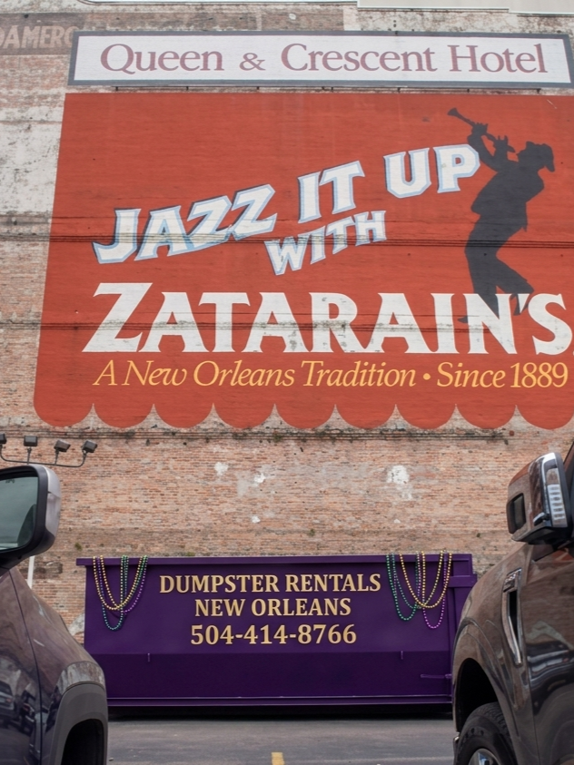 NOLA Dumpster Rentals dumpster beneath the historic Jazz It Up with Zatarain's mural in downtown New Orleans
